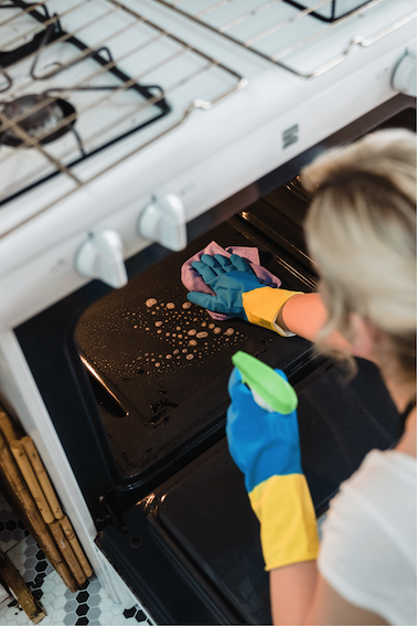 A women cleaning an oven furnace