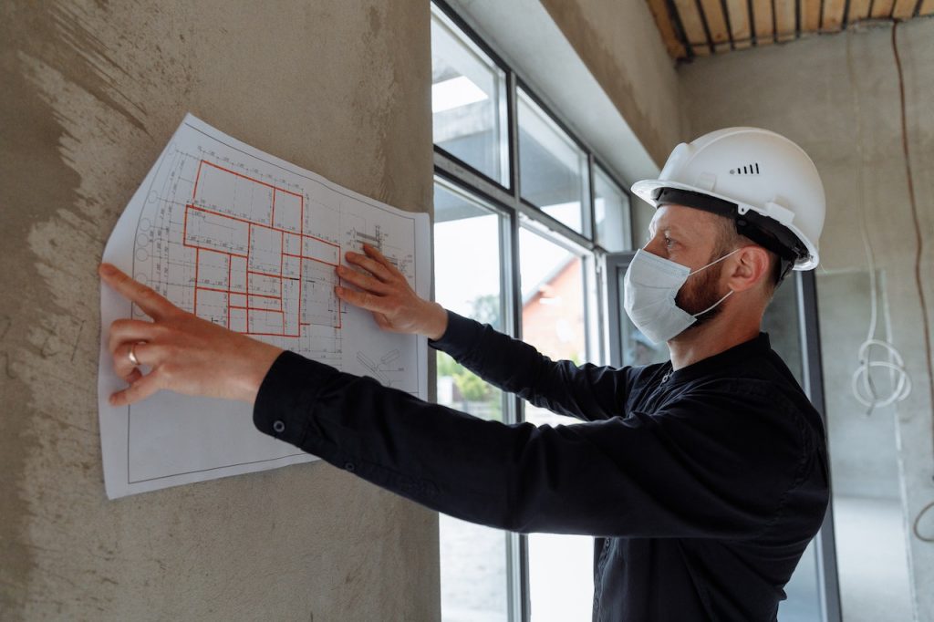 Architect worker with blueprints paper at house building